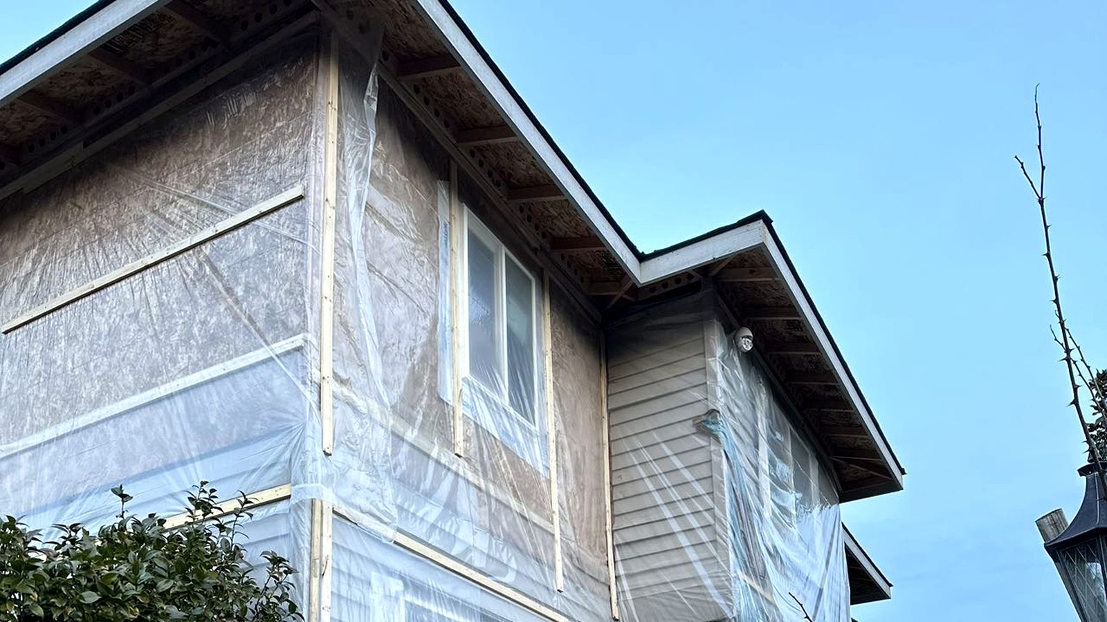 Eastside home wrapped in protective containment during active restoration by an RM crew.